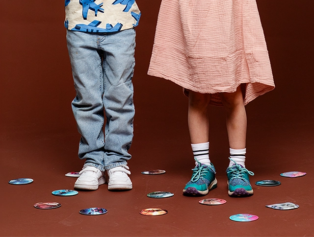 Unterkörper von Kindern umringt von Patchies, die auf dem Boden liegen