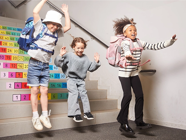 Drei Kinder springen von einer Treppe